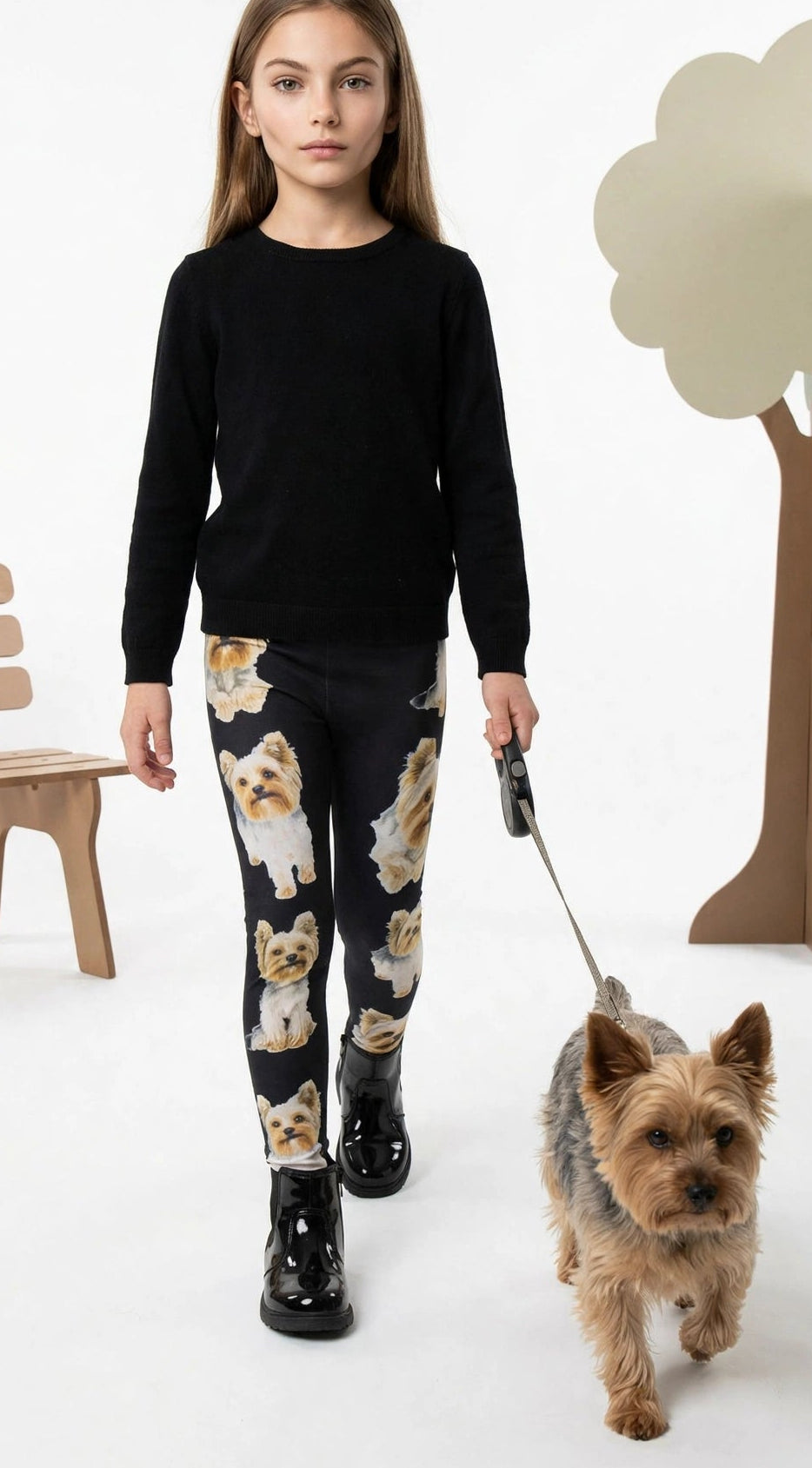 Young girl walking a real Yorkshire Terrier on a leash, wearing Denimaxx kids Yorkie Terrier print leggings and a black top.