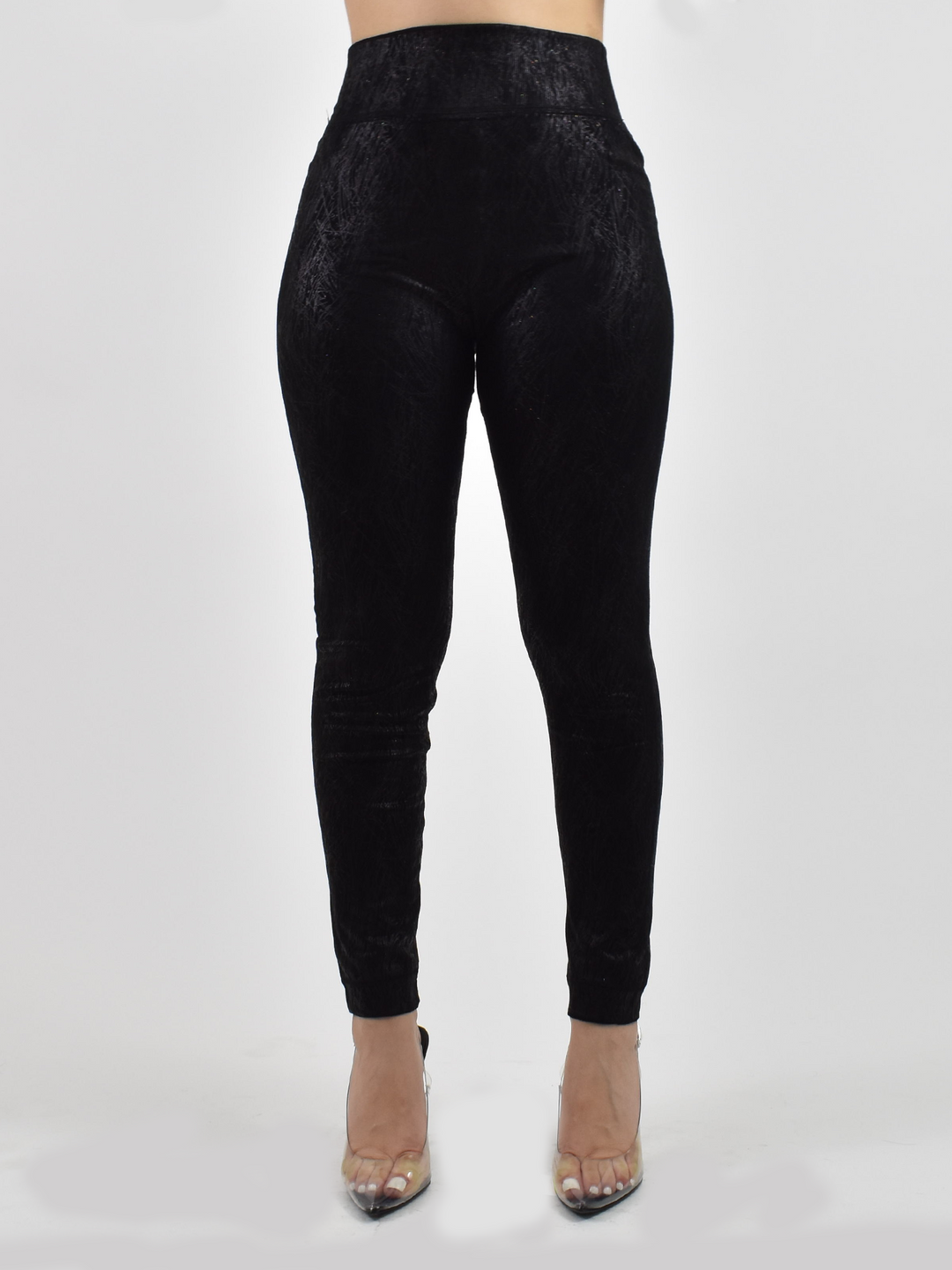 Woman wearing Denimaxx black lined leggings with textured fabric and high waistband, clear heels, front view.