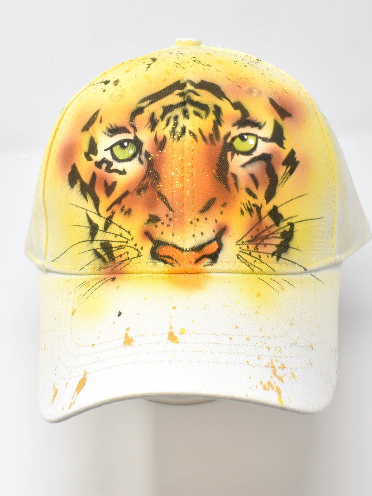 Front view of the white hand-painted territorial tiger baseball cap with orange tiger face and green eyes, studio shot.