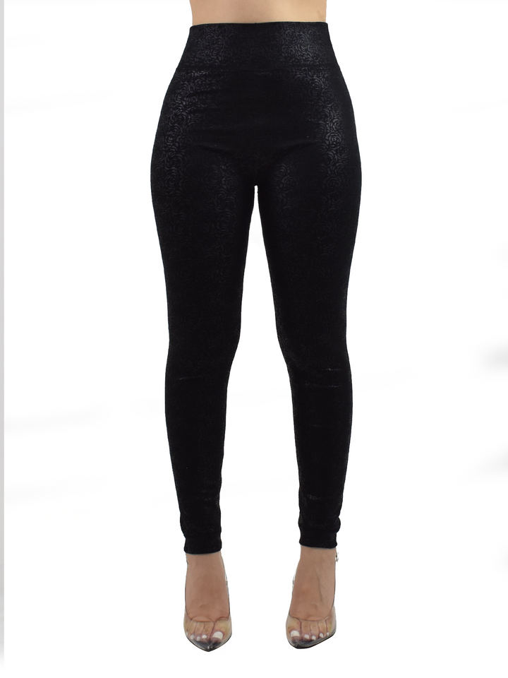 Woman wearing Denimaxx black lined leggings with a subtle embossed floral texture, clear heels, front studio view.