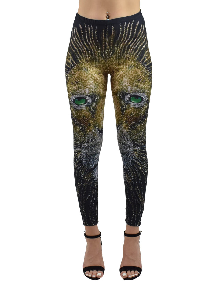Woman wearing Denimaxx Light of the Lion print leggings with a golden lion face and green eyes, paired with black strappy heels.