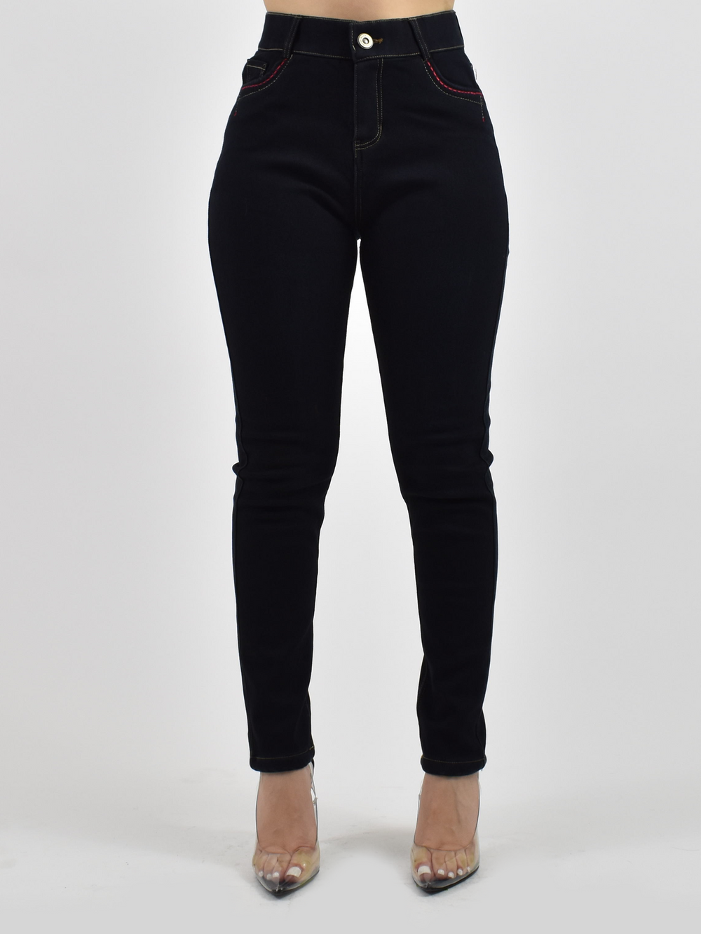Woman wearing Denimaxx black lined jean leggings with button fly and red stitching on the front pockets, clear heels.