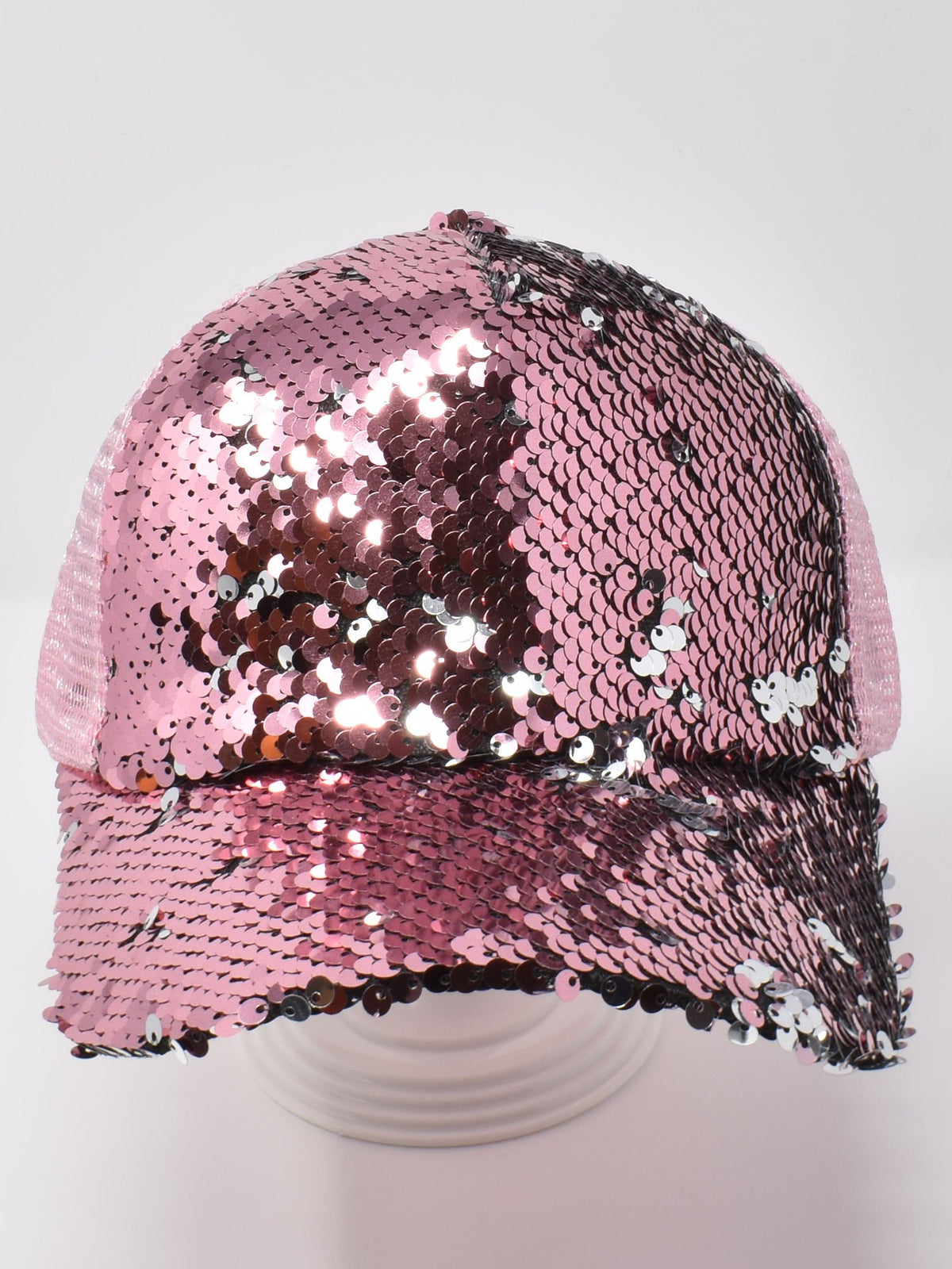 Champagne pink sequin baseball cap with shimmering pink and silver sequins and a mesh back, displayed on a stand.
