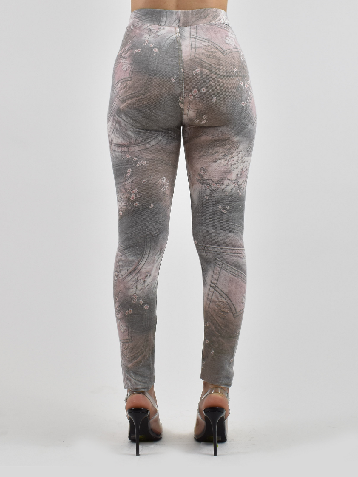 Back view of Jean pocket leggings with gray-pink denim floral print and stitched pocket details, studio shot with black heels.