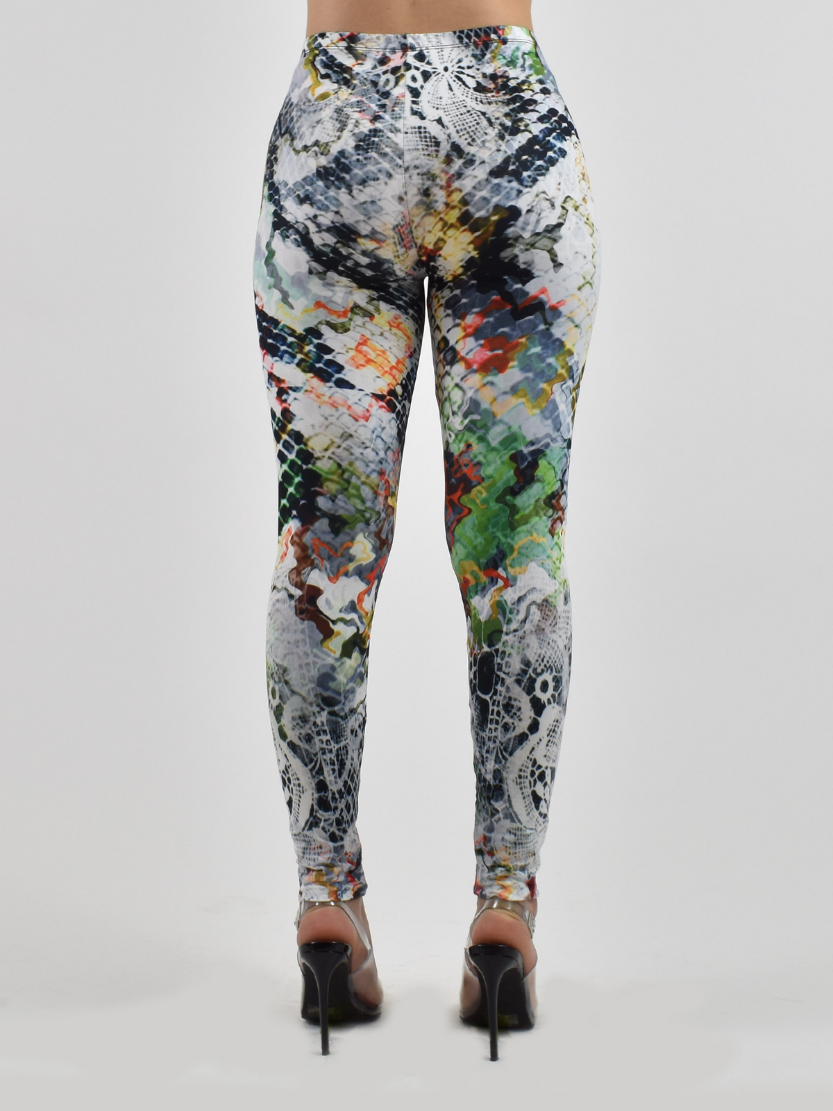 Back view of Dragon Scales print leggings showing the multicolor scale design, studio shot with black heels.
