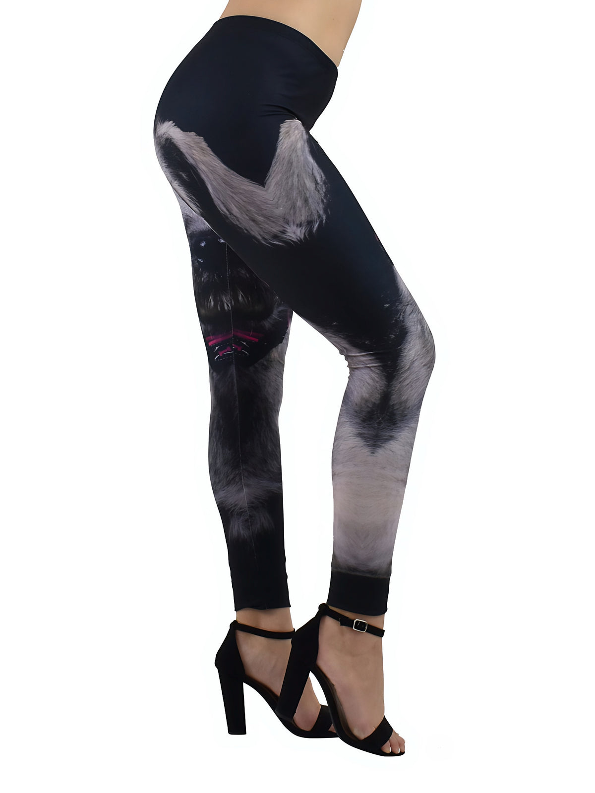 Young girl with one leg extended wearing kids leggings with a colorful mixed dog breed print, black tank top, and white socks indoors.