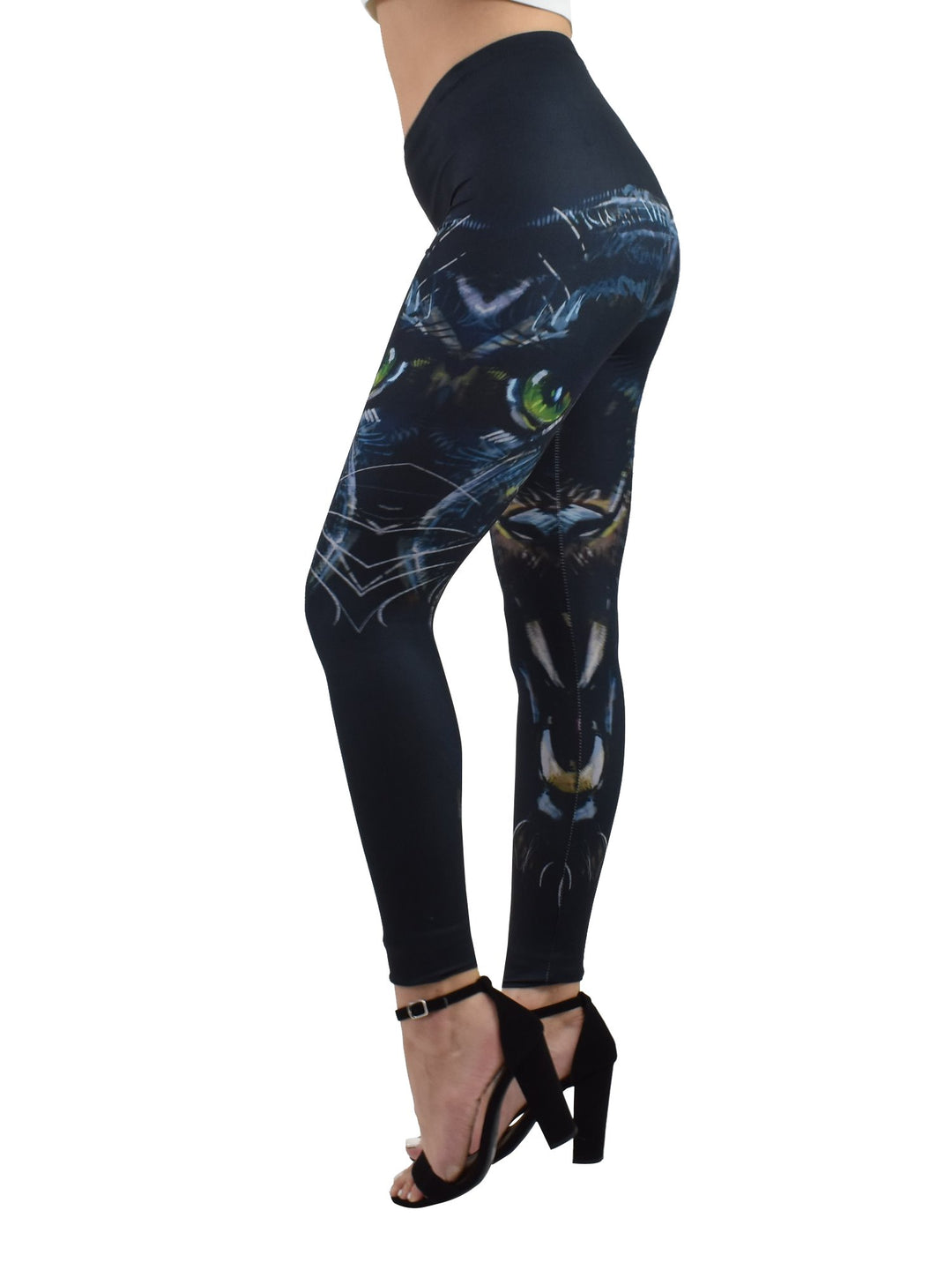Angled side view of Denimaxx Enraged Black Puma leggings with black puma face artwork and green eyes, worn with black block heels.