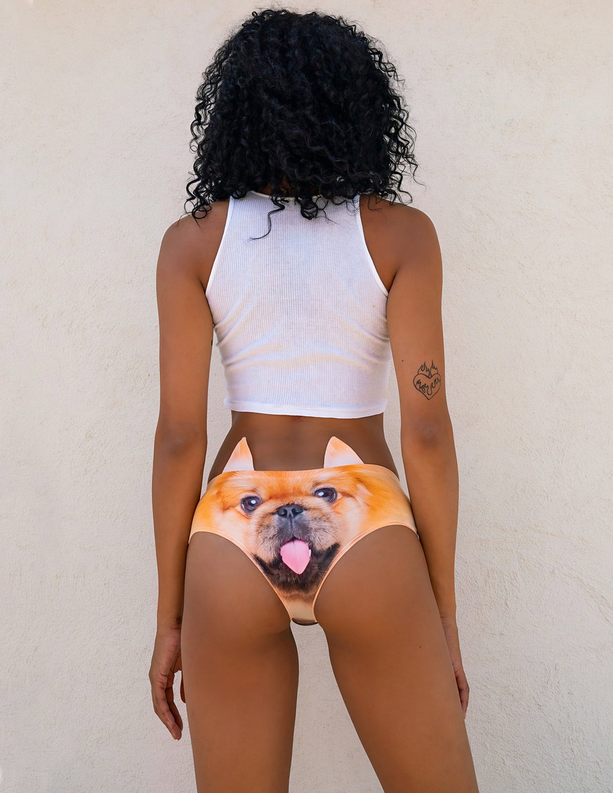 Back view of woman wearing Pekingese print panties showing the orange Pekingese face with its tongue out and ear tabs.