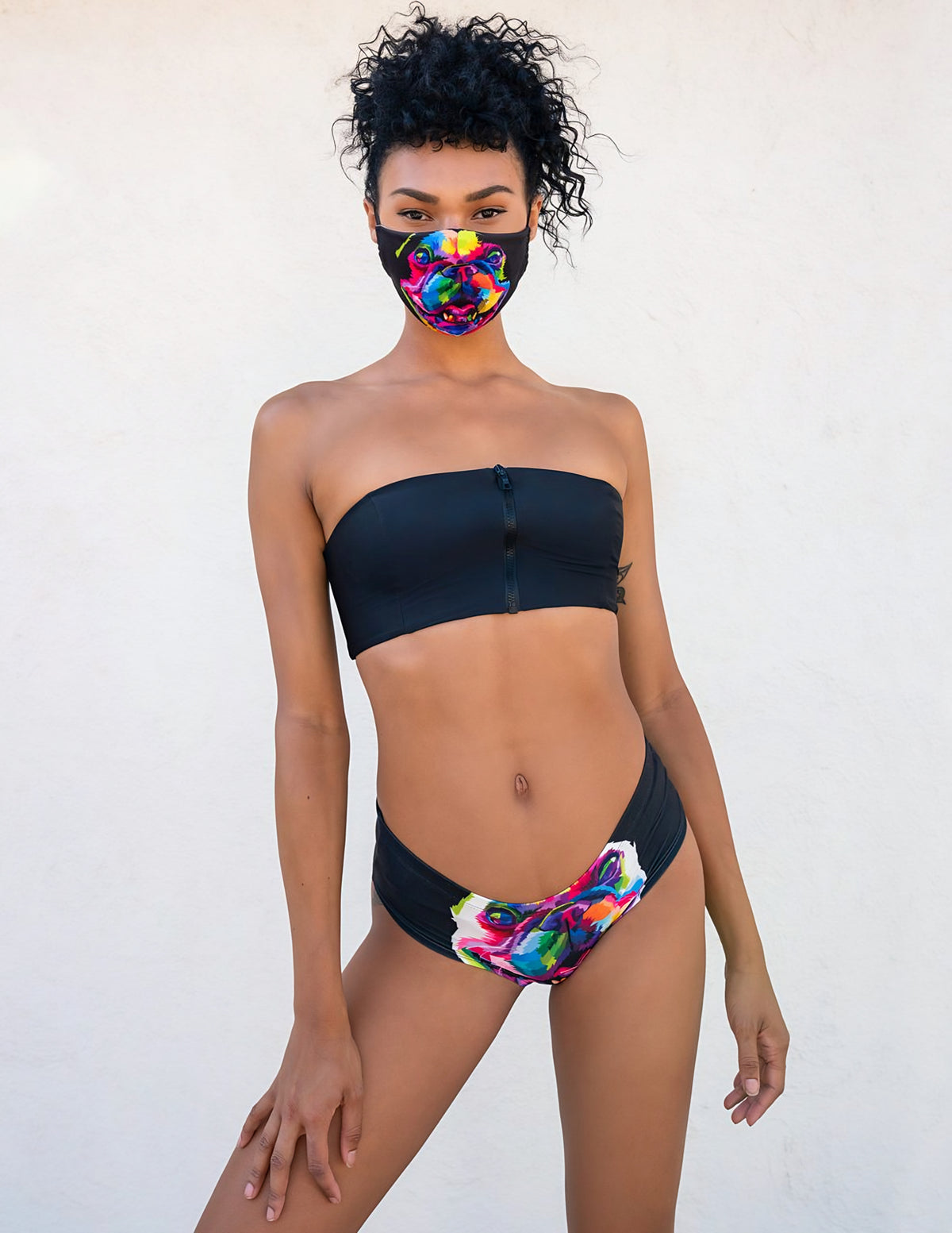 Front view of woman wearing Multicolor French Bulldog print panties with a black strapless top and bulldog print face mask.