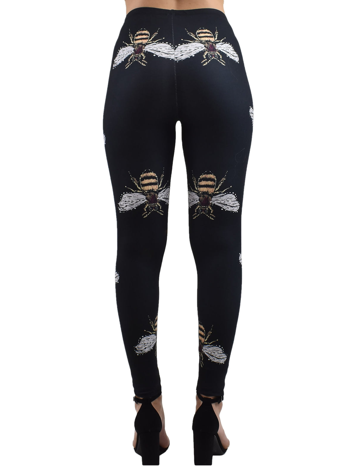 Back view of Honey Bees print leggings with bee illustrations across black fabric, studio product shot with black heels.