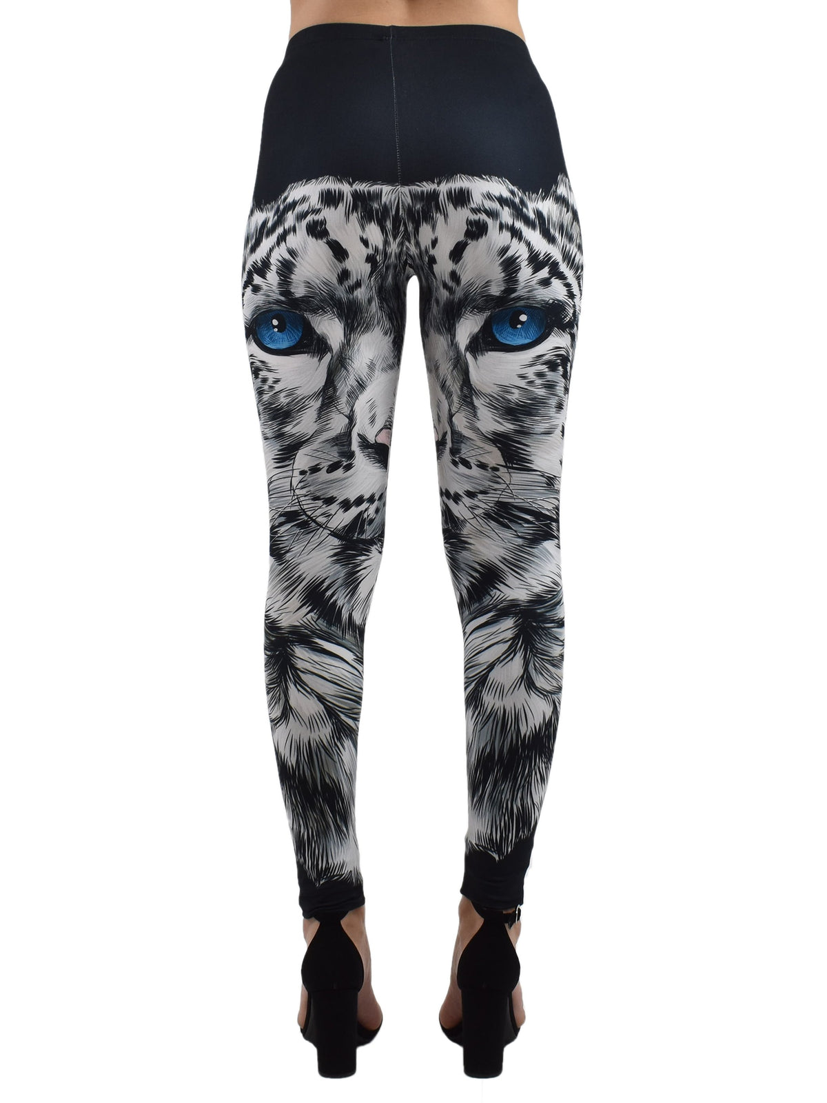 Back studio shot of snow leopard print leggings with blue-eyed snow leopard face on model in black heels, white background.