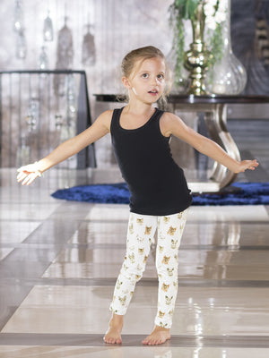 Young girl with arms out wide wearing kids white All-Over Kitty print leggings and a black tank top.