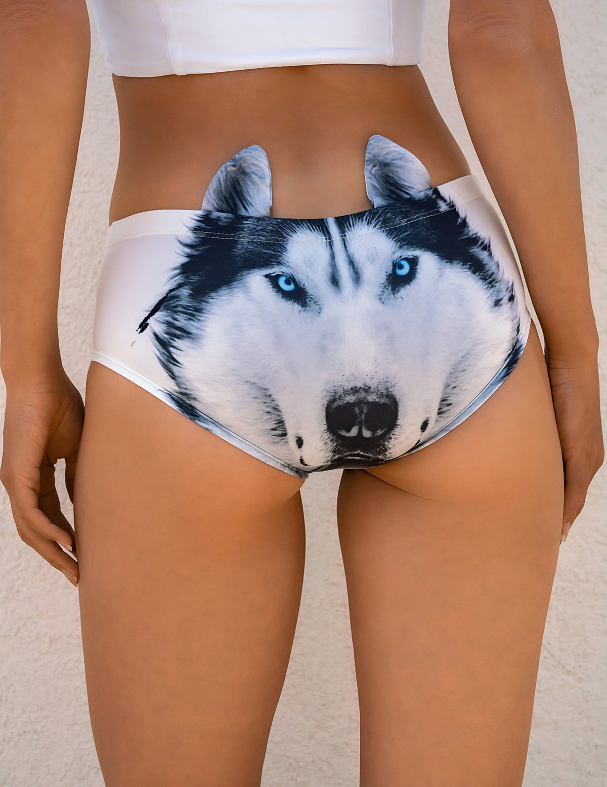 Woman wearing Husky Wolf print panties with a large blue-eyed husky face and upright ears, paired with a white crop top.