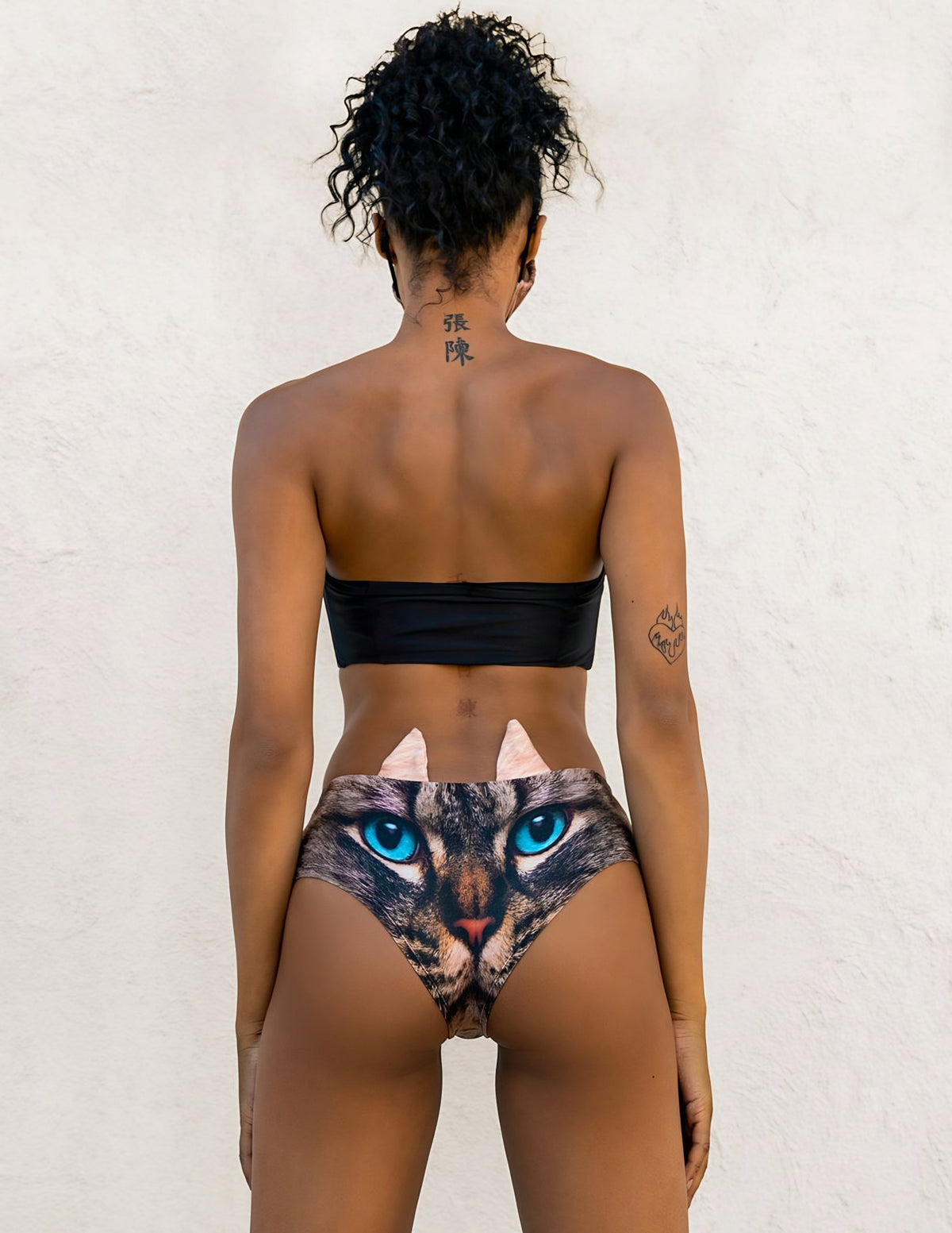 Back view of woman wearing Green-Eyed Cat print panties showing the tabby cat face with blue eyes and ear tabs.
